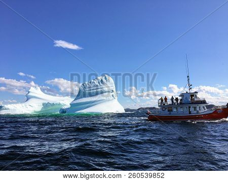 Twilingate, Newfoundland, Canada - July 23rd, 2017: A Tour Boat Viewing A Large Iceberg Off The Coas