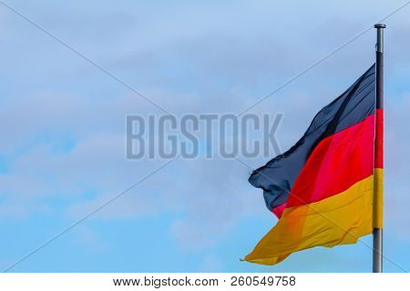 Federal Republic Of Germany, German National Flag Waving On The Blue Sky Background