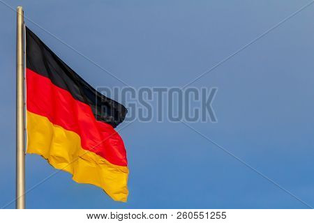 Federal Republic Of Germany, German National Flag Waving On The Blue Sky Background