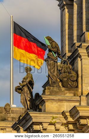 Federal Republic Of Germany, German National Flag At The Parliament Building Waving On The Blue Sky 