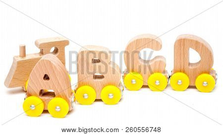 Wooden Letters A, B, C, D Of A Train Alphabet And Locomotive With Yellow Wheels On White Background.