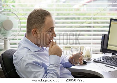 Stressed Businessman Having Severe Headache, Holding Painkiller Remedy Pill. Office Worker Thinking 