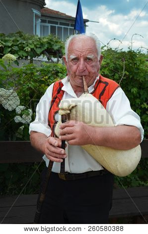 Nesebr, Bulgaria - 16 June, 2013: An Elderly Gray-haired Man Is Holding A Gaida. Traditional Spiritu