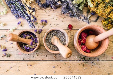 Preparation of medicinal herbs, dry flowers, ayurveda, wooden background, lavender