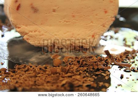 Chocolate Ice Cream And Hardered Chocolate Over On The Black Plate