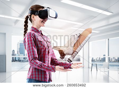 Young Caucasian Woman In Modern Office Interior Trying Virtual Reality Helmet And Viewing Space Shut