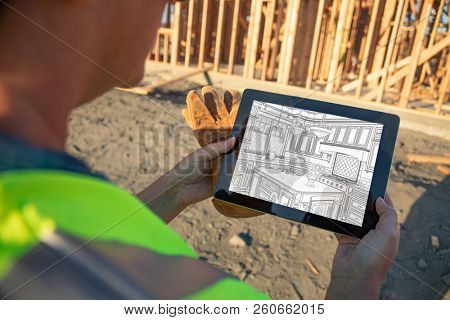Female Construciton Worker Reviewing Kitchen Drawing on Computer Pad at Construciton Site.