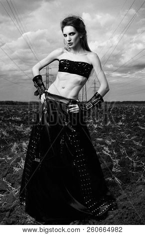 Informal Fashion: The Attractive Slender Young Gothic Woman Dressed In Black Leather Skirt And Glove
