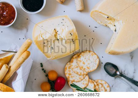 Cachotta Cheese With Herbs, Jam, Baguette, Crackers, Rosemary And Thyme On Marble