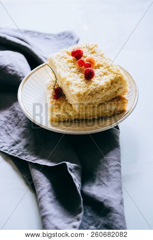 Pieces Of Cottage Cheese Cake With A Crumble Decorated With Raspberries And Red Currants On A White