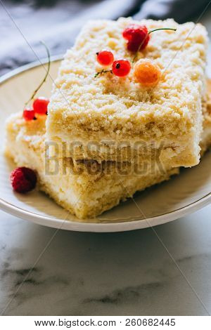 Pieces Of Cottage Cheese Cake With A Crumble Decorated With Raspberries And Red Currants On A White