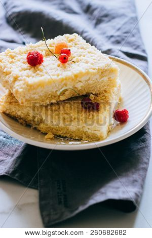 Pieces Of Cottage Cheese Cake With A Crumble Decorated With Raspberries And Red Currants On A White 