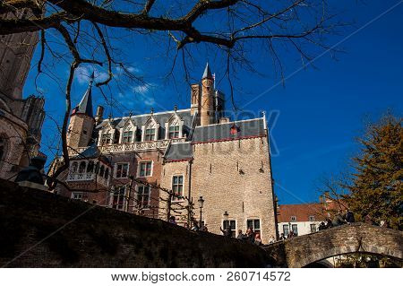 Bruges, Belgium - March, 2018: Bonifacius Bridge And The Building With The Smallest Window Of The Hi