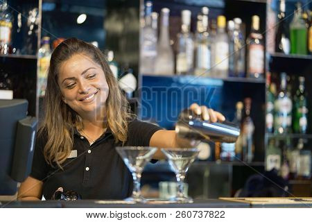Professional Barman Girl Pours A Fresh Cocktail To The Customers Of The Hotel Bar. The Bartender Gir