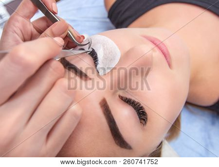 Eyelash Extension Procedure. Beautiful Woman With Long Lashes In A Beauty Salon.