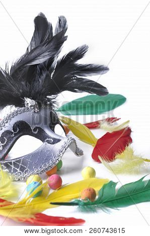 Beautiful Carnival Mask Among Colorful Feathers On White Background