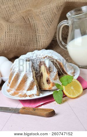 Sliced Homemade Marble Cake Sprinkled With Sugar, Lemon, Melissa, Milk, Eggs And Butter - Vertical P