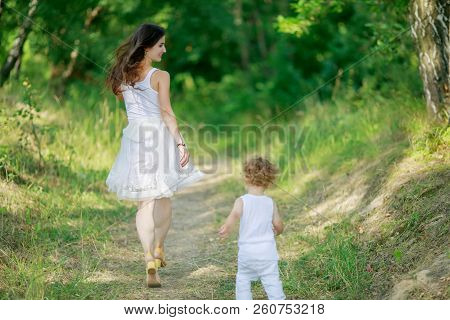Mother And Son Having Fun Running And Playing Together At The Patk.