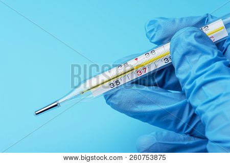 Hand In Glove Holding A Thermometer Of Public Health And Medicine.