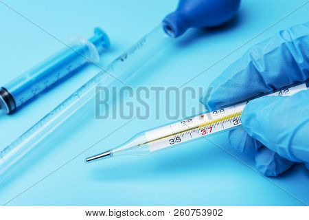 Hand In Glove Holding A Thermometer Of Public Health And Medicine.