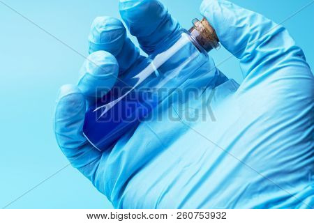 Close-up Of Glass Tube With Blue Fluid In Scientist Hand During Medical Test