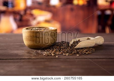 Lot Of Whole Fresh Brown Flaxseeds In A Scoop With Wooden Bowl With Rustic Wood Kitchen In Backgroun