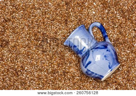 Lot Of Whole Fresh Brown Flaxseeds With Blue Jar Flatlay Isolated