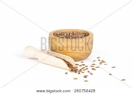 Lot Of Whole Fresh Brown Flaxseeds In A Scoop With Wooden Bowl Isolated On White Background