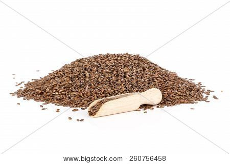 Pile Of Lot Of Whole Fresh Brown Flaxseeds With Wooden Scoop Isolated On White Background