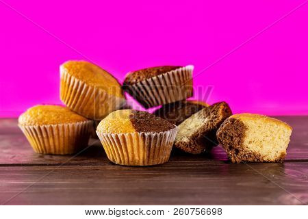 Group Of Five Whole Two Halves Of Fresh Baked Marble Muffin With Pink In Background