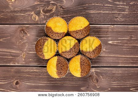 Group Of Seven Whole Fresh Baked Marble Muffin Flatlay On Brown Wood