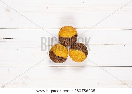 Group Of Three Whole Fresh Baked Marble Muffin Flatlay On White Wood
