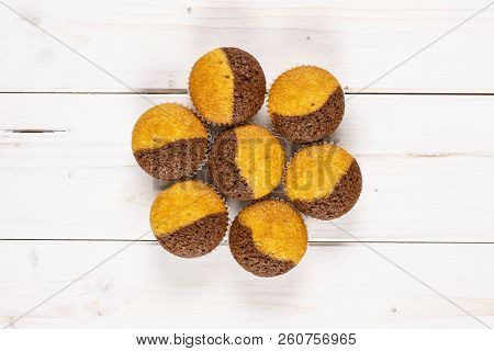 Group Of Seven Whole Fresh Baked Marble Muffin Flatlay On White Wood