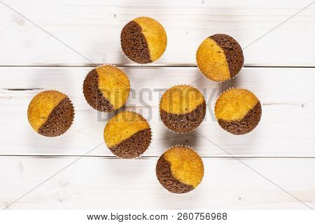 Group Of Eight Whole Fresh Baked Marble Muffin Flatlay On White Wood