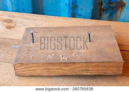 Wooden Block With Two Nails In Workshop Cabinetry Repair Work Bench With Blue Wall