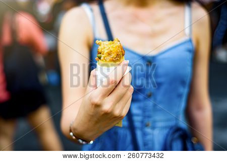 Girl Eating Chicken Wing Snuffed With Rice In The Street