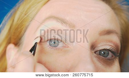Super Close-up, A Woman Doing Her Eye Make-up, Paints The Eyelid With Shadows.
