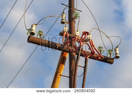 Mast Of The Power Line Against The Blue Sky.