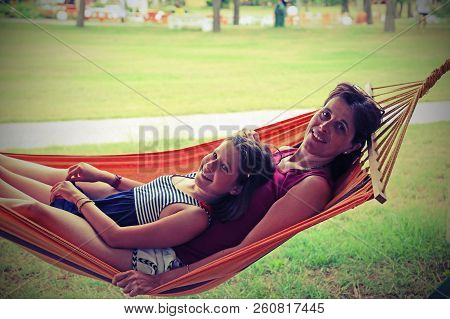 Mom And Daughter Relaxes On The Hammock In The Tourist Village In The Summer With Vintage Effect
