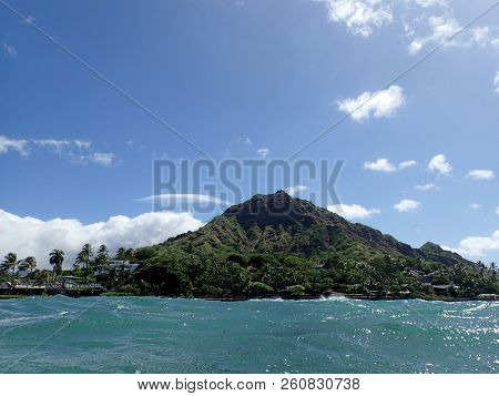 Diamond Head Crater Towers Over Makalei Beach Park With Seawall, Coconut Trees, Homes And Clouds On 