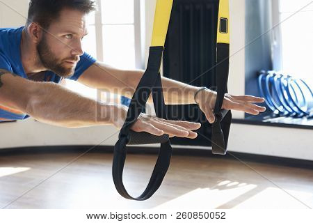 Handsome Muscular Man Athlete Doing Exercise Alone With Fitness Belts In Modern Gym Club, Workout Si
