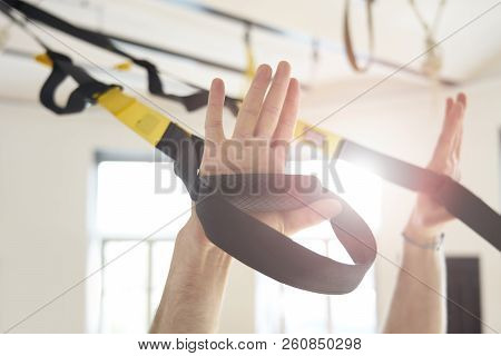 Close-up Of Man Hands With Training Belts, A Guy Doing Workout In Sport Club, Daylight.