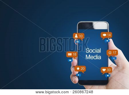 Hand Holding Mobile Smart Phone, With Notification Icons. Social Media On Mobile Phone