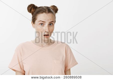 Impressed And Surprised Attractive Girlfriend With Buns Hairstyle And Freckles, Lifting Eyebrows In 