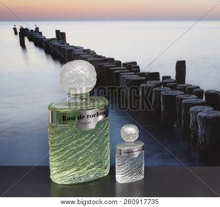 Eau De Rochas, Fragrance For Ladies, Large Perfume Bottle Next To A Commercial Perfume Bottle In Fro