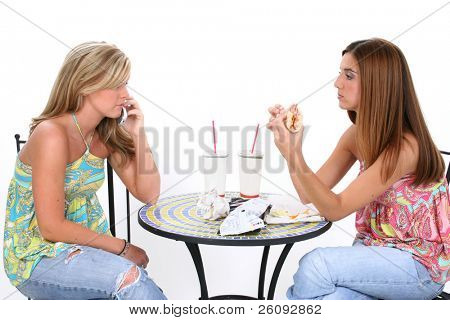zwei schöne junge Frauen Mittagessen zusammen an kleinen Bistrotisch. Lachen und auf die