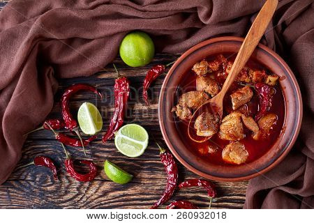 Hearty Red Chile And Pork Stew Or Carne Adobada In A Clay Bowl With Spoon On An Old  Wooden Table Wi