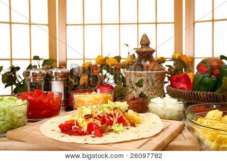 Burrito petit déjeuner dans la cuisine ou au restaurant.  Oeufs, fromage, tomate, laitue, oignon, chipotle, bacon.