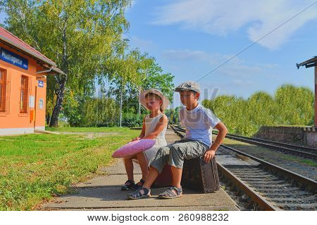 Little  Children - Girl And Boy On A Railway Station, Waiting For The Train With Vintage Suitcase. T