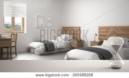 White Table Or Shelf With Crystal Hourglass Measuring The Passing Time Over Blurred Modern Bedroom W